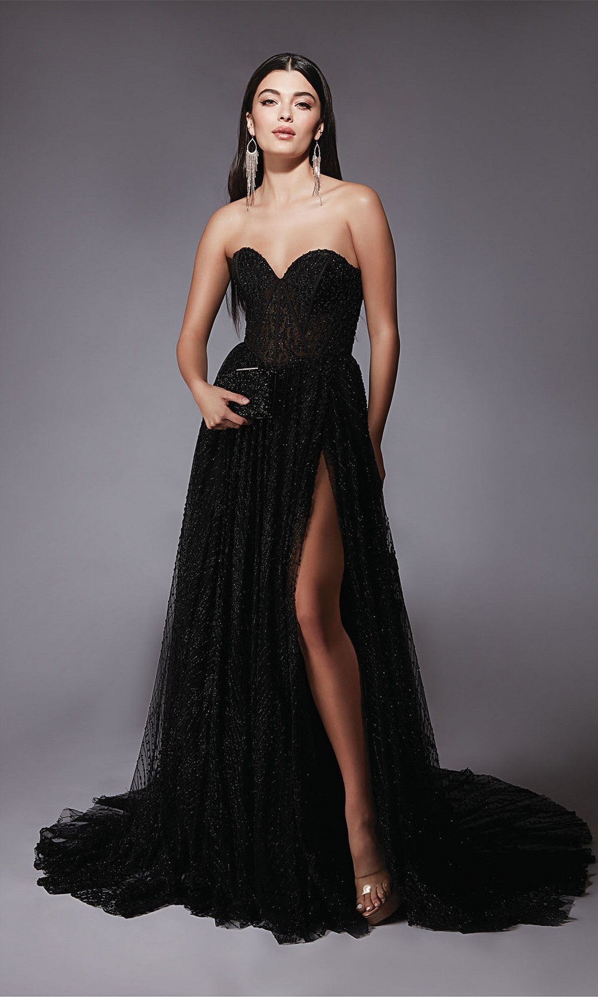 Woman poses gracefully against a plain gray background in the Alyce 7133 long formal dress, black, featuring a strapless sheer bodice, high slit, and long train.